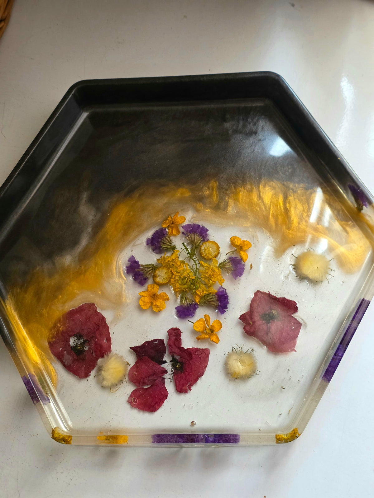 Hexagonal resin tray with preserved red poppy petals, yellow and purple wildflowers and gold accents - angle view