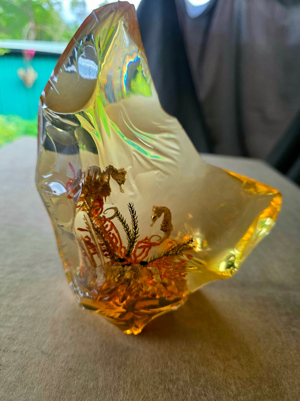 Golden amber resin crystal with seahorses - side view