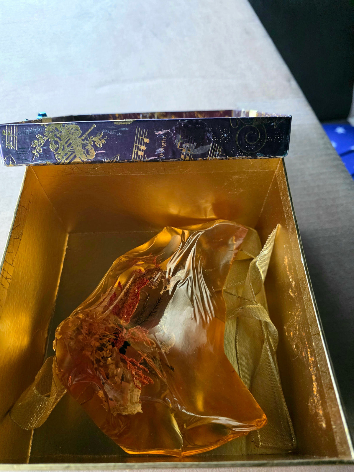 Golden amber resin crystal in gift box - angle view